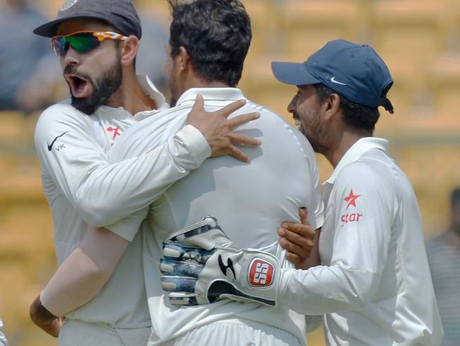 Indian bowler Umesh Yadav (2R) celebrates with captain Virat Kohli (C) and his team mates, the dismissal of Australian captain Steve Smith during the fourth day of the second Test match between India and Australia at The M. Chinnaswamy Stadium in Bangalore on March 7, 2017. / AFP PHOTO / Manjunath KIRAN / ----IMAGE RESTRICTED TO EDITORIAL USE - STRICTLY NO COMMERCIAL USE----- / GETTYOUT