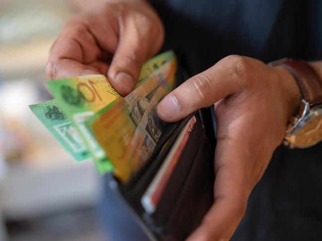 a male taking money out of a wallet, Australian cash generic spending