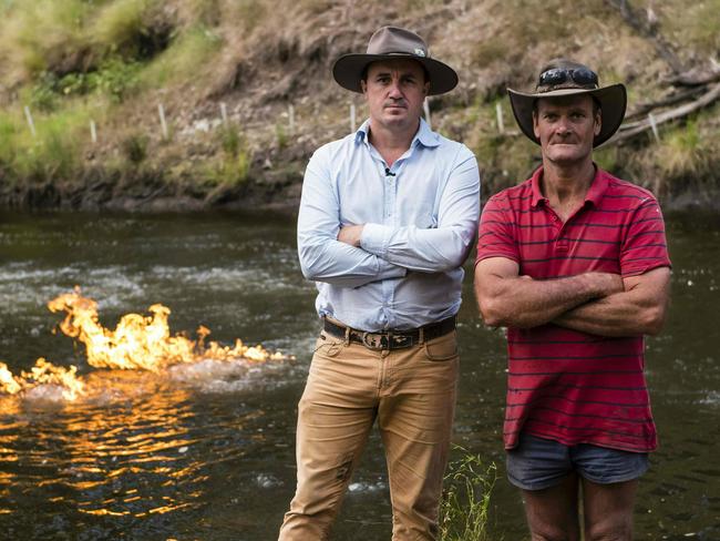 This handout photo from the New South Wales Greens Party taken on April 12, 2016 and released on April 24, 2016 shows Australian Greens MP Jeremy Buckingham (L) posing with local resident John Jenkyn (R) after he set fire to methane gas along the Condamine River (behind) in Queensland, about 220 kilometres (140 miles) west of Brisbane. Buckingham used a kitchen lighter to ignite bubbles of methane in the river to draw attention to methane gas he says is seeping into the water due to fracking. / AFP PHOTO / NSW GREENS / Max Phillips / ----EDITORS NOTE ----RESTRICTED TO EDITORIAL USE MANDATORY CREDIT " AFP PHOTO / MAX PHILLIPS / NSW GREENS" NO MARKETING NO ADVERTISING CAMPAIGNS - DISTRIBUTED AS A SERVICE TO CLIENTS - NO ARCHIVES