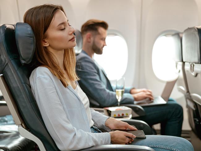 Interior of commercial airplane with passengers in their seats during flight.