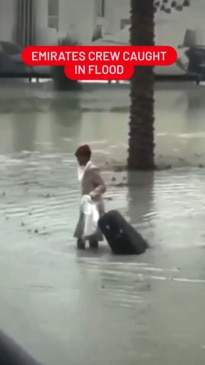 Emirates flight attendant seen trudging through flood water