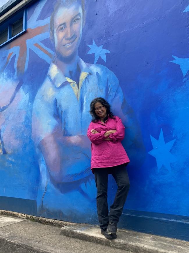 Felice Burton in front of the Macksville mural she painted of Phil Hughes