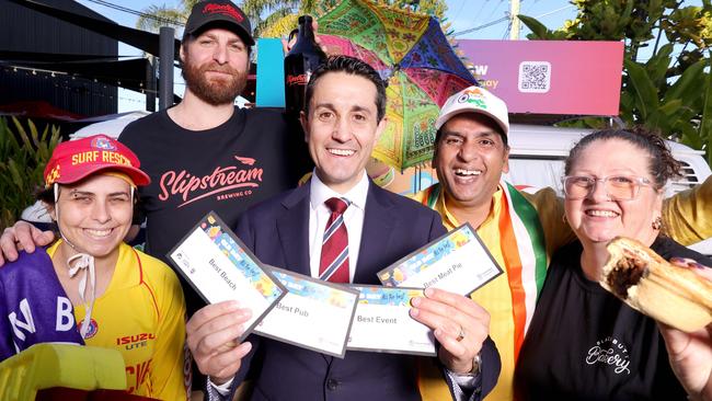 Premier David Crisafulli, with from left, Faith Liberato from Coolum Beach SLSC, Chris Genitempo from Slipstream Brewing Co, Nick Attam the Secretary of India Fest Townsville inc and Blackbutt Bakery’s Mandy Nelson holding a curry sausage pie. Picture: Steve Pohlner