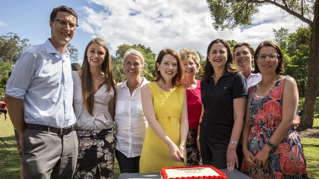 Queensland Premier Annastacia Palaszczuk cuts a cake with winning Labor candidates at a barbecue. Picture: AAP/Glenn Hunt