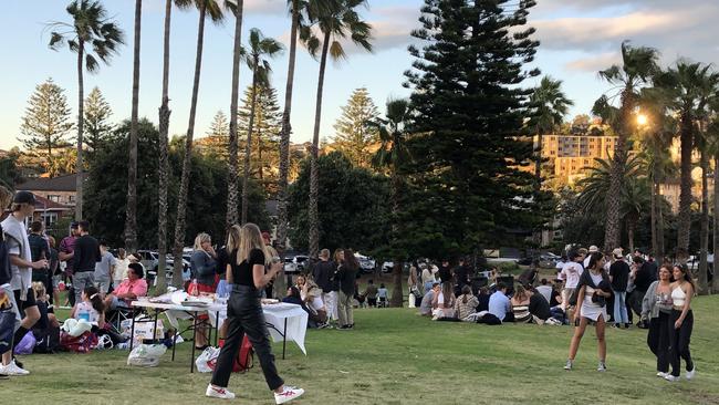 People gathering to socialise at about 6.45pm on Saturday at the reserve behind Freshwater Surf Life Saving Club. Picture: Jim O'Rourke