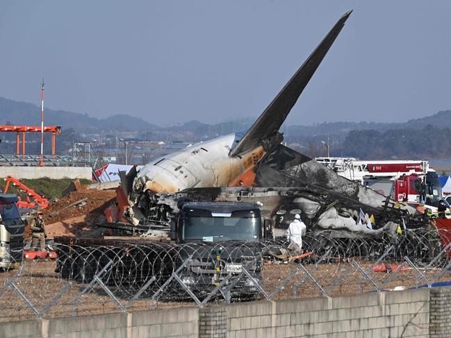 Firefighters and rescue personnel work near the wreckage of a Jeju Air Boeing 737-800 series aircraft after the plane crashed and burst into flames at Muan International Airport. Picture: AFP