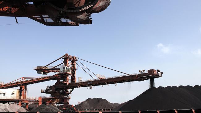 China’s crude steel output has fallen in each of the past three months. Above, a conveyor belts dumps iron ore on to a pile for the Shanghai International Port Group. Picture: Bloomberg