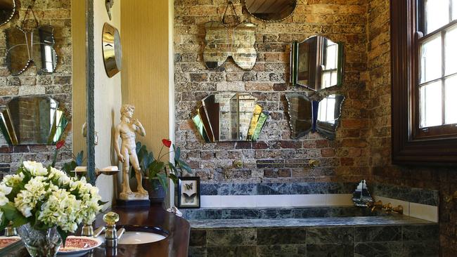 Bathroom features green Italian marble tiles and a collection of Art deco era mirrors. Picture: John Appleyard