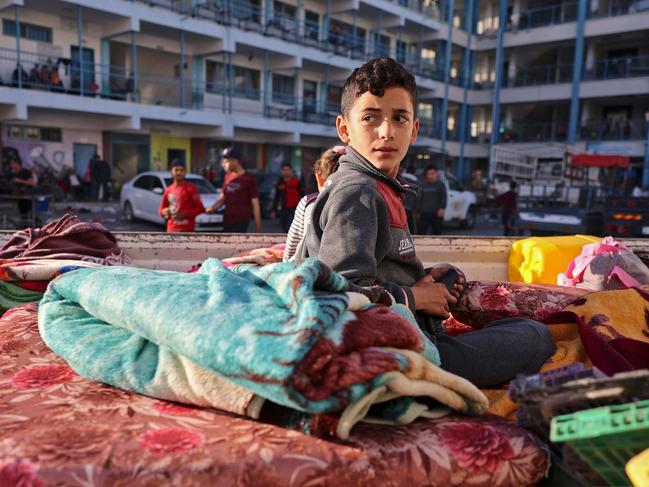 A Palestinian boy who fled his home due to Israeli air and artillery strikes sits on a mattress outside at a school hosting refugees in Gaza city. Picture: AFP