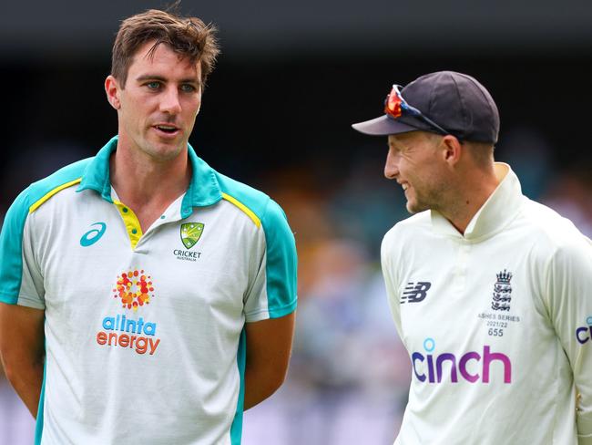 England's captain Joe Root (R) and Australia's Pat Cummins (L), wait to be interviewed at the conclusion of the first Ashes cricket Test match between England and Australia at the Gabba in Brisbane on December 11, 2021. (Photo by Patrick HAMILTON / AFP) / -- IMAGE RESTRICTED TO EDITORIAL USE - STRICTLY NO COMMERCIAL USE --