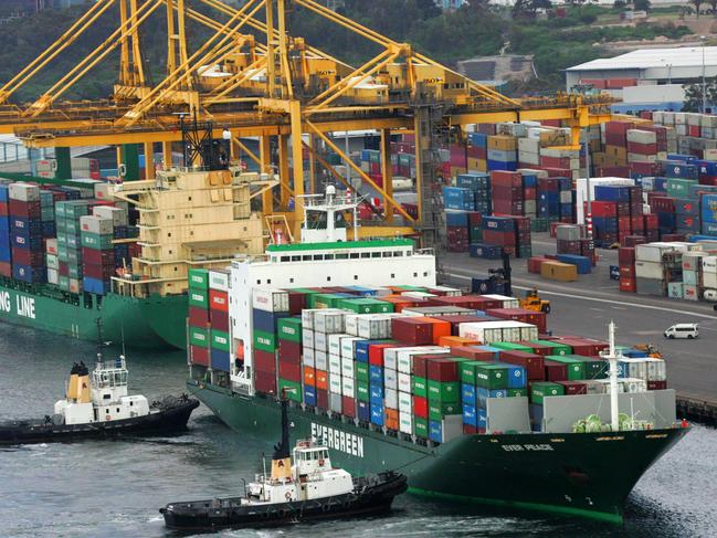 A container ship is pushed by two tugs towards the wharf at Port Botany, Sydney, where thousands of containers are already stored.