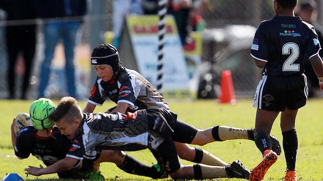 Rouse Hill Rhino’s under-10 players involved in a tackle.