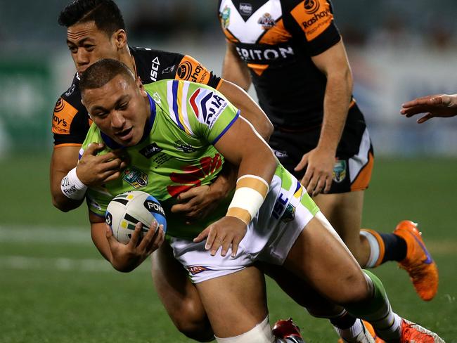 Raiders Josh Papalii is wrapped up by Tigers Tim Simona at GIO Stadium in 2015. Papalii is worth $355,400. Picture Gregg Porteous