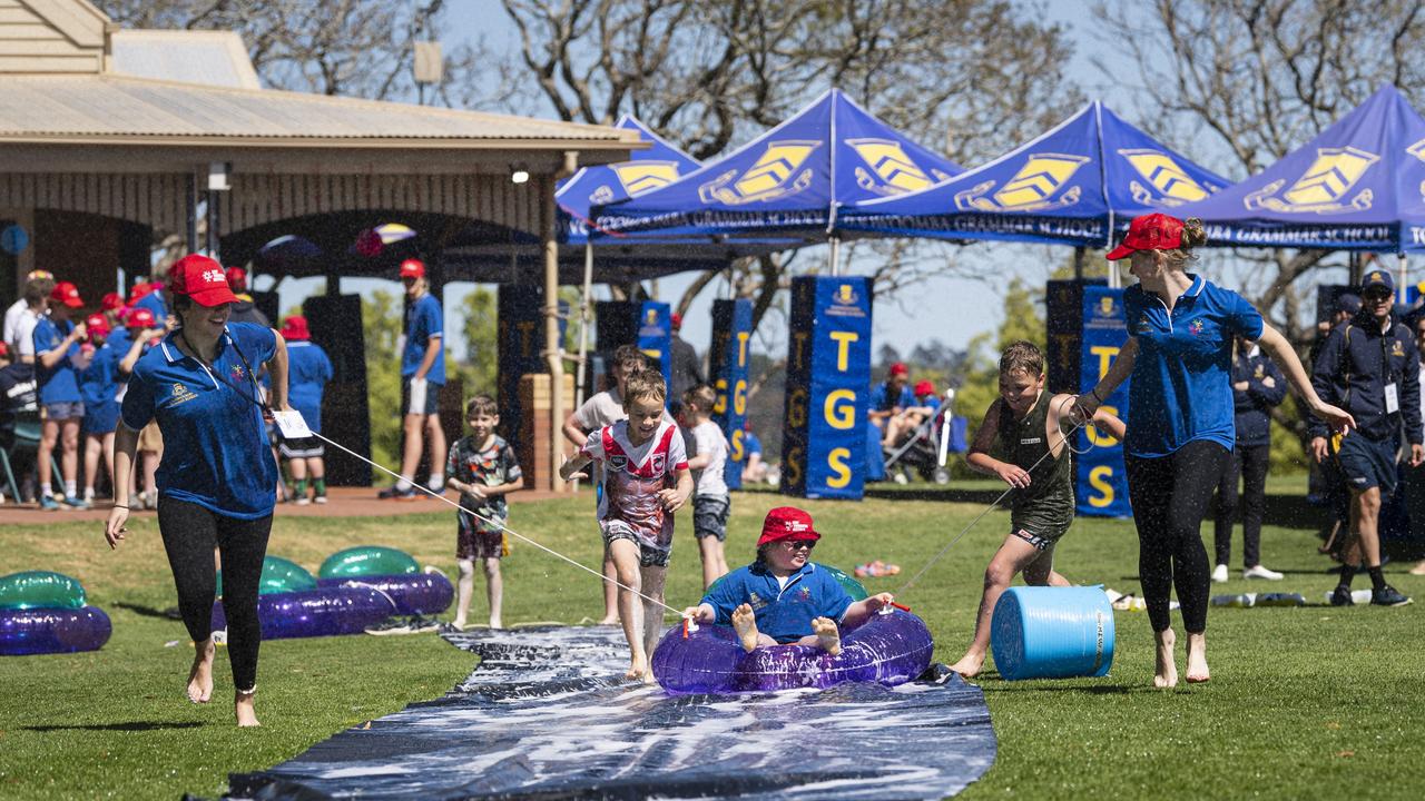 Fairholme College students Sophie Wise (left) and Harriet Beattie pull Charlotte along the slip and slide as Toowoomba Grammar School hosts the Sony Foundation Children's Holiday Camp, Monday, September 16, 2024. Picture: Kevin Farmer