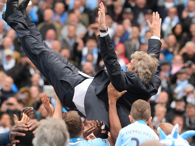 Manchester City's Chilean manager Manuel Pellegrini is thrown in the air by his players as they celebrate after winning the Premiership title following the English Premier League football match between Manchester City and West Ham United at the Etihad Stadium in Manchester on May 11, 2014. AFP PHOTO/ANDREW YATES RESTRICTED TO EDITORIAL USE. No use with unauthorized audio, video, data, fixture lists, club/league logos or “live” services. Online in-match use limited to 45 images, no video emulation. No use in betting, games or single club/league/player publications.