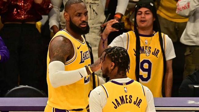 Los Angeles Lakers' US small forward #23 LeBron James (L) and Los Angeles Lakers' US guard #09 Bronny James are seen on court during the NBA game season opener between the Los Angeles Lakers and the Minnesota Timberwolves at Crypto Arena in Los Angeles on October 22, 2024. LeBron and Bronny are the first father and son to play together in any NBA game. (Photo by Frederic J. Brown / AFP)