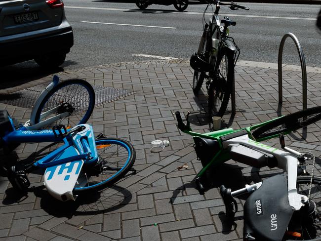 DAILY TELEGRAPH. Share e-bikes from Lime and Hello Ride lay tipped over on the sidewalk at Martin Place, Sydney. 05/02/2024. Picture by Max Mason-Hubers