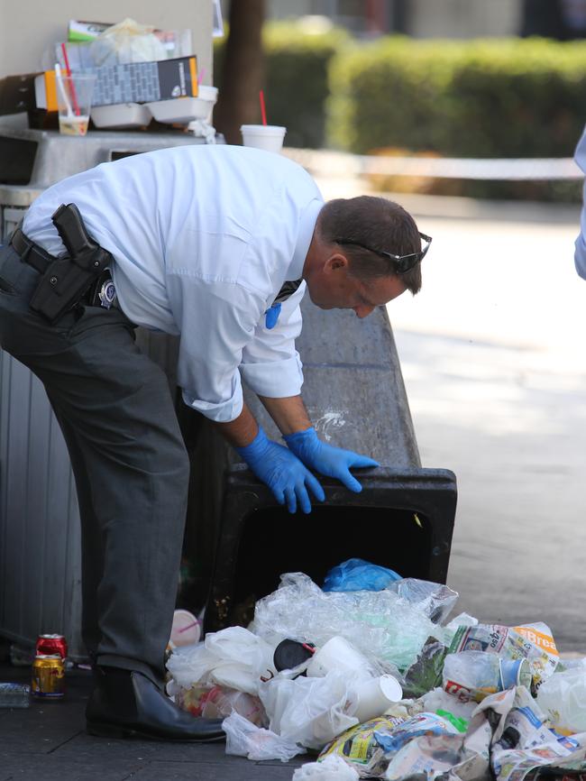 A bin is overturned in hunt for clues.