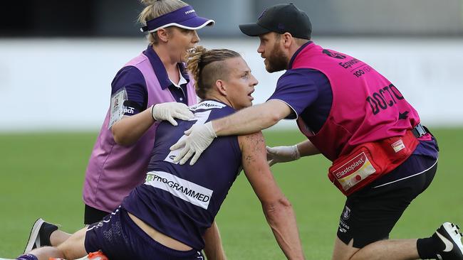 Nat Fyfe in the hands of trainers after being bumped in the head by Giant Sam Reid. Picture: Will Russell/AFL Photos via Getty Images