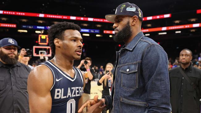 (FILES) In this file photo taken on December 11, 2021 Bronny James #0 of the Sierra Canyon Trailblazers is greeted by his father and NBA player LeBron James after defeating the the Perry Pumas in the Hoophall West tournament at Footprint Center in Phoenix, Arizona. - LeBron James has agreed to terms on a two-year NBA contract extension with the Los Angeles Lakers worth $97.1 million, according to multiple reports on Wednesday. (Photo by Christian Petersen / GETTY IMAGES NORTH AMERICA / AFP)