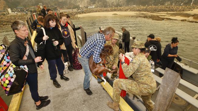 The first of the passengers are loaded on to the landing boats by ADF personal. Picture: David Caird