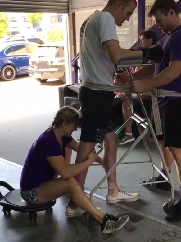 McKinnon walking with assistance during rehab.