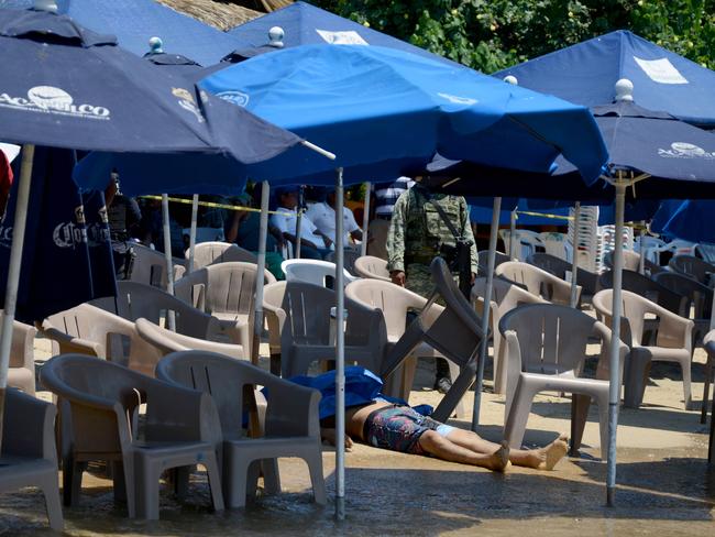 The corpse of a murdered man lies by the shore of a tourist area in Caletilla Beach, Acapulco.