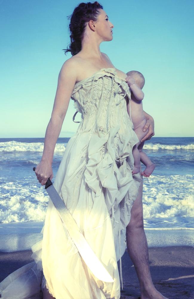 Palmer with baby Ash, and machete, by the sea.