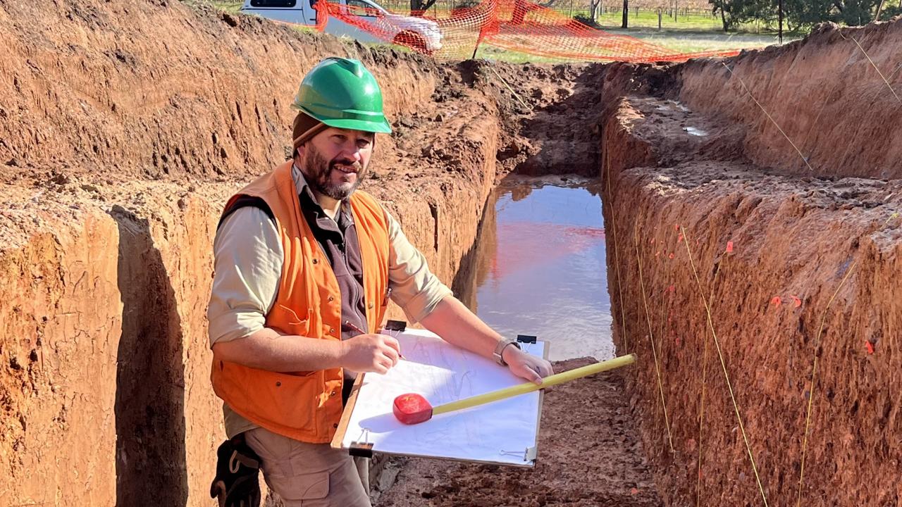 Geoscience Australia earthquake geologist Dr Dan Clark examines the trench on the Willunga Fault. Credit: Geoscience Australia