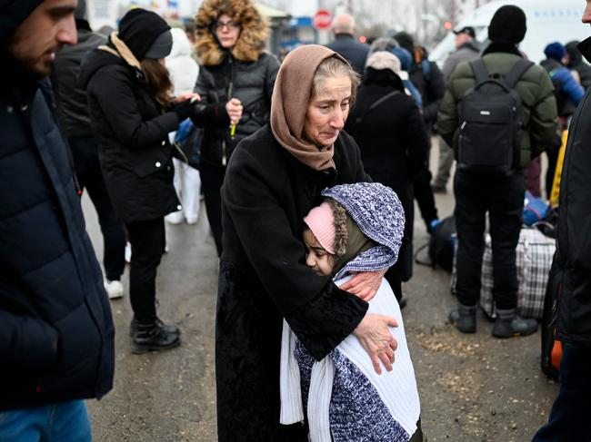 A woman hugs a girl as refugees from Ukraine wait for a transport at the Moldova-Ukrainian border's checkpoint near the town of Palanca. Picture: Nikolay Doychinov/ AFP