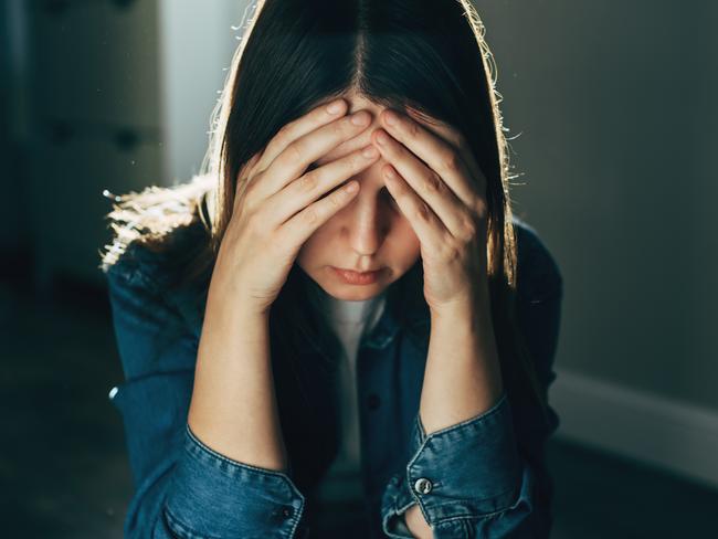 Silhouette of sad and depressed woman sitting on the floor at home