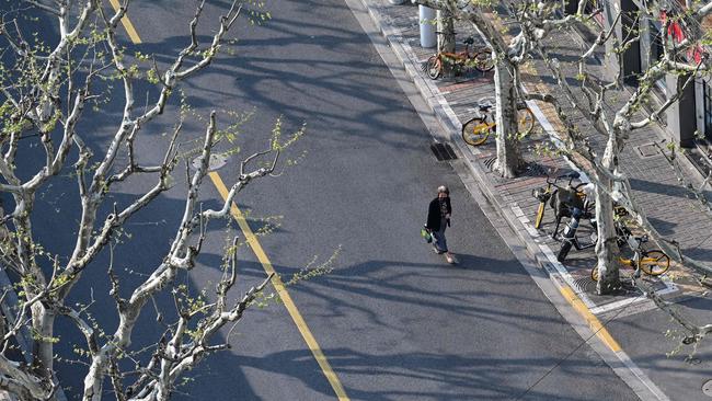 A woman walks on an empty street in Shanghai. Picture: Hector Retamal/AFP