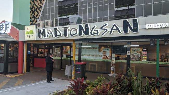 Madtongsan IV restaurant at Sunnybank's Market Square is closed after it was revealed one of the coronavirus positive teenagers dined there. The assistant centre manager stands out the front. Picture: Alex Treacy