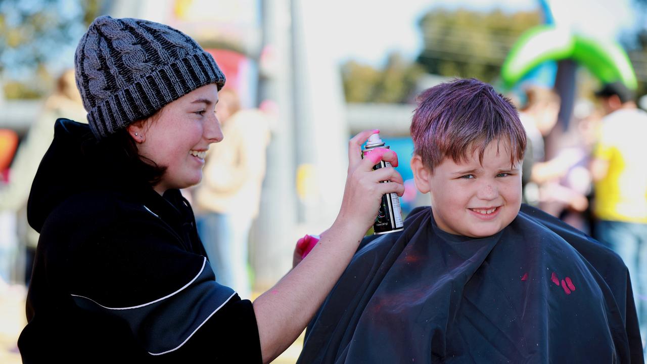 Natasha Sills sprays pink hair colour to 7 year old Ethan Stewart. (AAP IMAGE / Angelo Velardo)