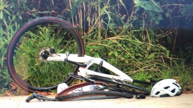 A damaged bike at the scene of a collision between a car and two cyclists on Forest Way at Belrose early on June 4. One of the riders died two days after the incident. Picture: Jim O’Rourke