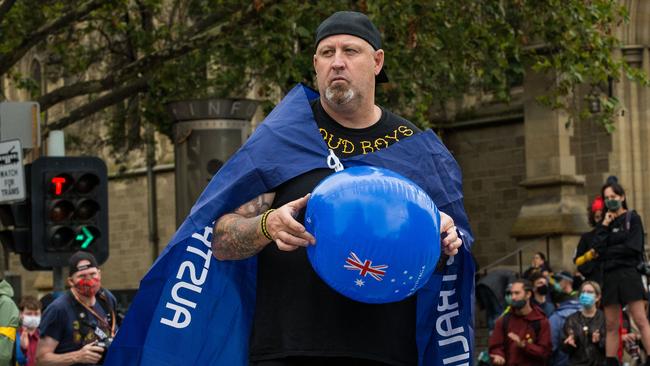 A man wearing a 'Proud Boys' shirt and an Australian flag attends an Invasion Day rally in Melbourne on Australia Day. Picture: Darrian Traynor/Getty Images