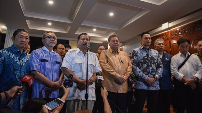 Flanked by sombre members of his coalition outside his Jakarta home, Prabowo Subianto announces Gibran Rakabuming Raka as his running mate on Sunday.