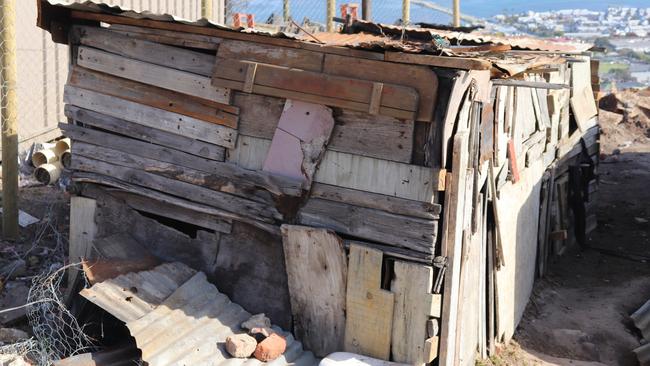 A shanty house in South Africa's Knysna township — with no standing room — overlooks million dollar waterfront properties below.