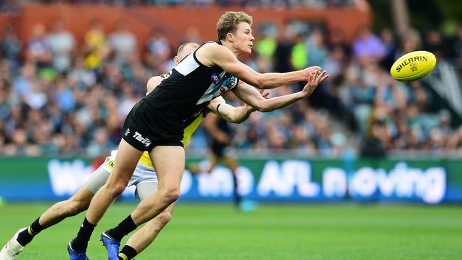 Xavier Duursma gets a handball away during Port’s loss to Richmond on Saturday night. The fourth-gamer had a shot to put the Power in front with two minutes to go but missed. Picture: Mark Brake (Getty)