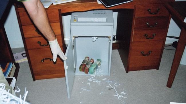 Police locate a stash of cash inside the paper shredder.