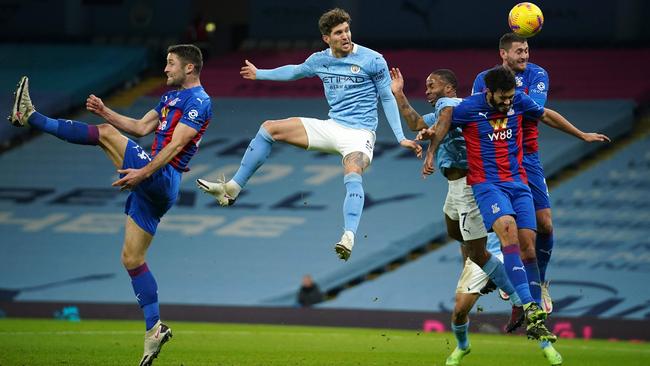 Man City’s John Stones heads the ball among a host of Crystal Palace defenders