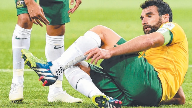 Australia's captain Mile Jedinak (R) injures his ankle against Kuwait as teammate Tim Cahill (L) looks on during the opening football match of the AFC Asian Cup in Melbourne on January 9, 2015. AFP PHOTO / William WEST --IMAGE RESTRICTED TO EDITORIAL USE - STRICTLY NO COMMERCIAL USE--