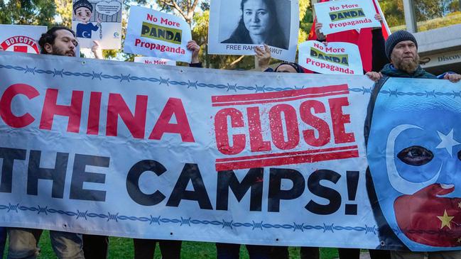 ADELAIDE, AUSTRALIA - NewsWire Photos - 16 JUNE, 2024:  Uyghur and counter-China demonstrators hold a banner and placards as they await the arrival of China's Premier Li Qiang at the Adelaide Zoo in Adelaide on June 16, 2024. Picture: NewsWire / Asanka Ratnayake / POOL