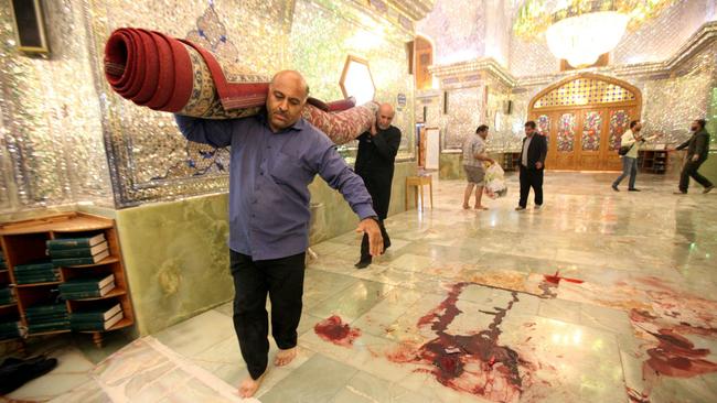 Workers clean up the scene following an armed attack at the Shah Cheragh mausoleum in the Iranian city of Shiraz on October 26 where at least 15 people were killed. Picture: AFP