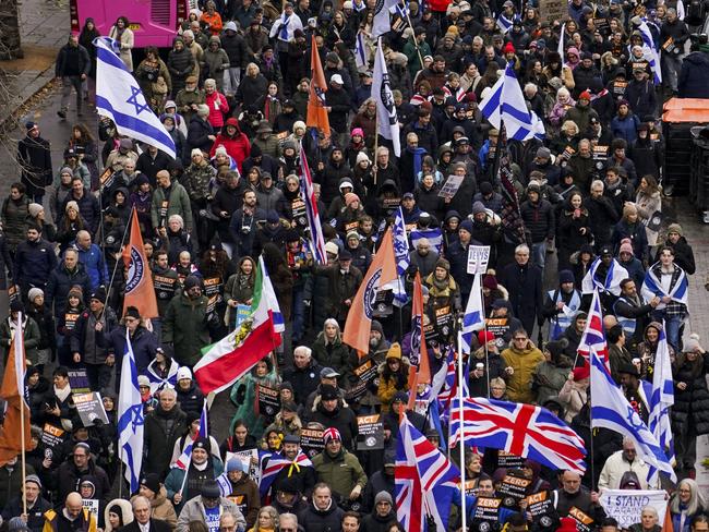 People hold placards and wave flags as they attend a march against antisemitism, in London, Sunday, Dec. 8, 2024.(AP Photo/Alberto Pezzali)