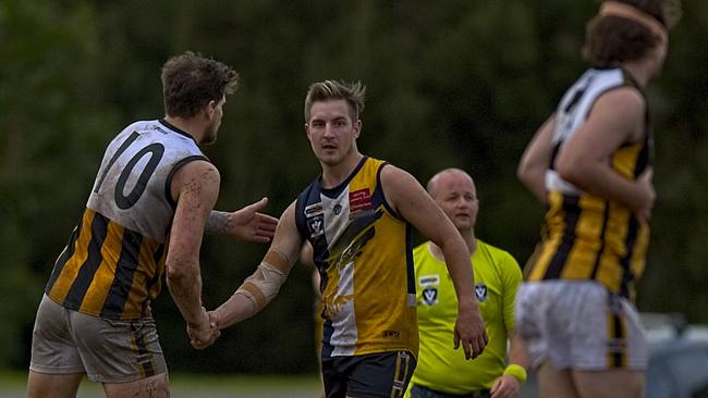 Beaconsfield and Upwey Tecoma players shake hands after the final siren in their match this year.