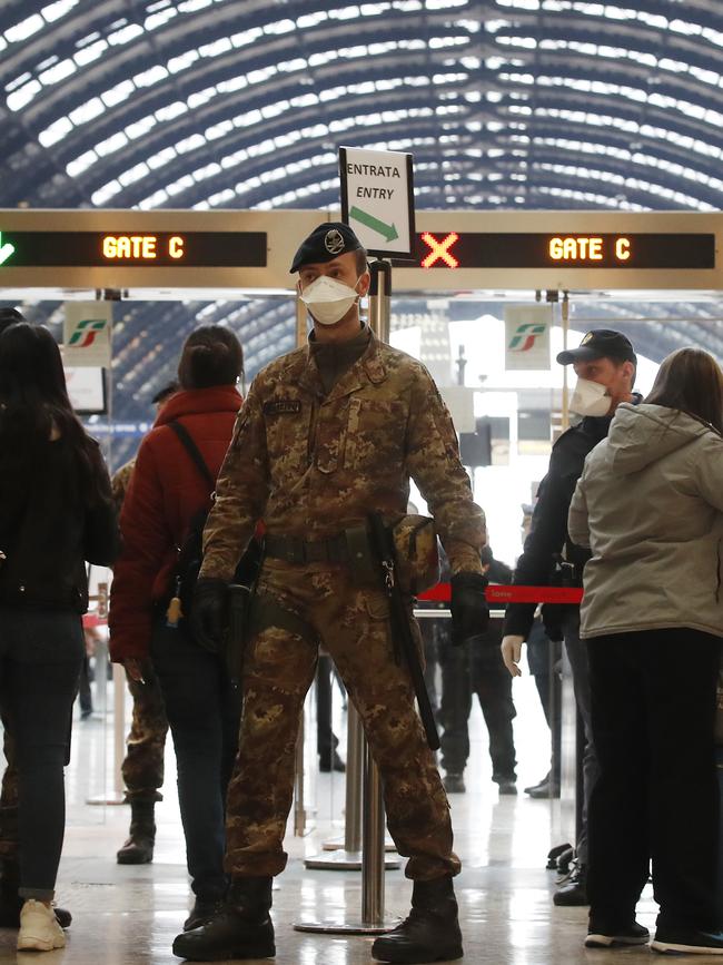 Police officers and soldiers check passengers leaving from Milan’s main train station. Picture: AP