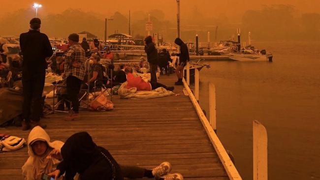 People shelter on the dock at Mallacoota. Picture: Instagram.