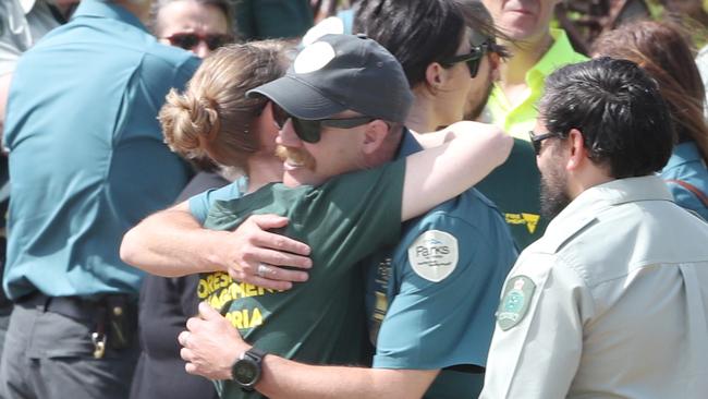 A Parks Victoria worker embraces a Forest Fire Management worker at the funeral of Bill Slade. Picture: AAP