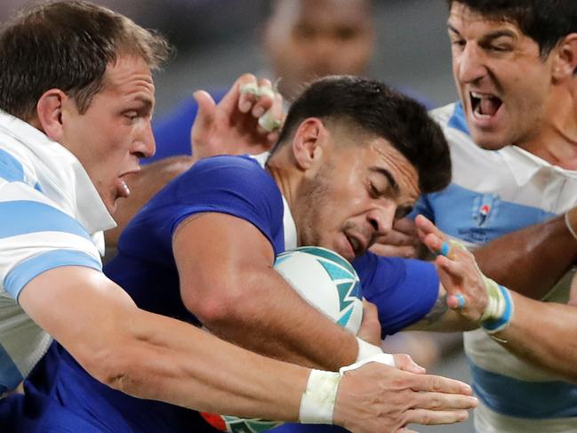 France's Romain Ntamack is tackled by Argentinian defenders during the Rugby World Cup Pool C game at Tokyo Stadium between France and Argentina in Tokyo, Japan, Saturday, Sept. 21, 2019. (AP Photo/Christophe Ena)